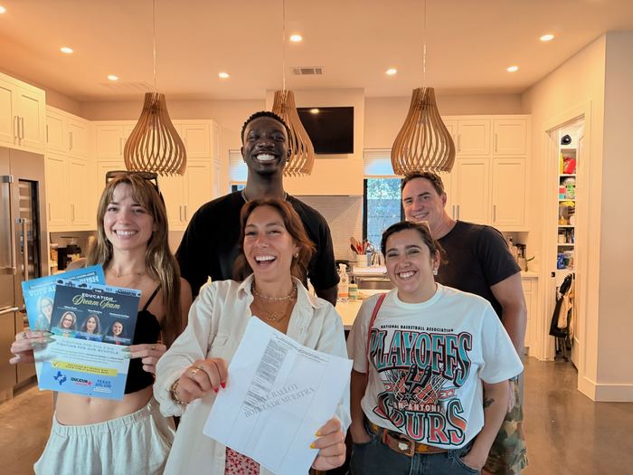 Friends gathered in a kitchen with a sample ballot and campaign mailers